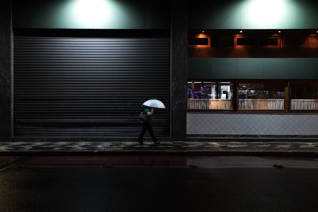 A man walking alone on a dark street at night