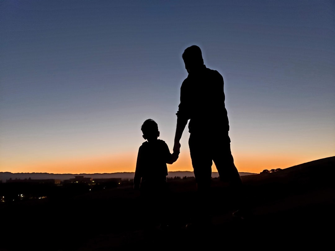 silhouette of father and son shaking hands