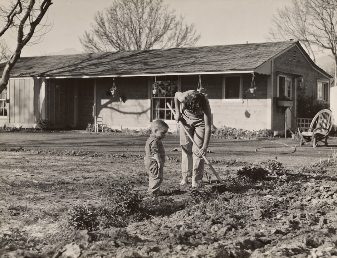 two kids playing with dogs in a yard