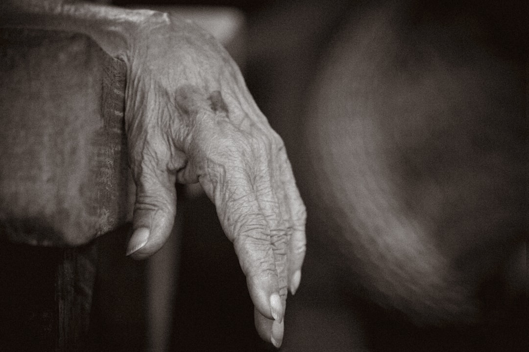 old wrinkled hand reaching for a youthful face