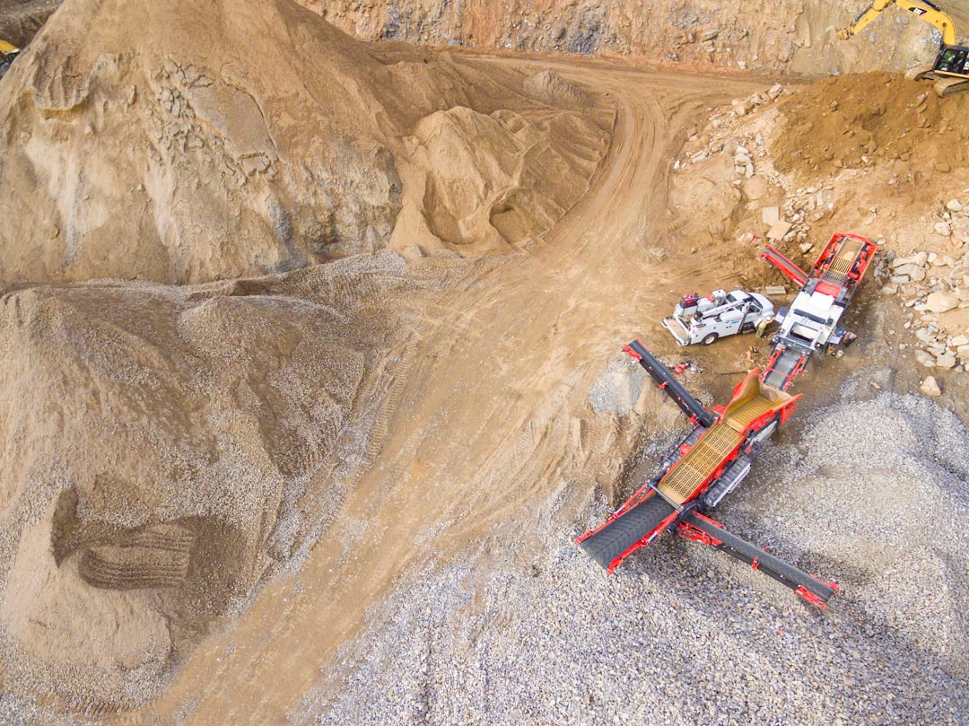 Aerial view of a large open-pit mine, focusing on the scale of the operation and the machinery involved.