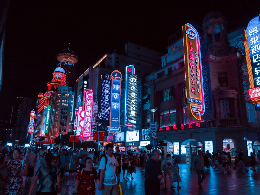 a crowded city street in China at night, neon lights flashing
