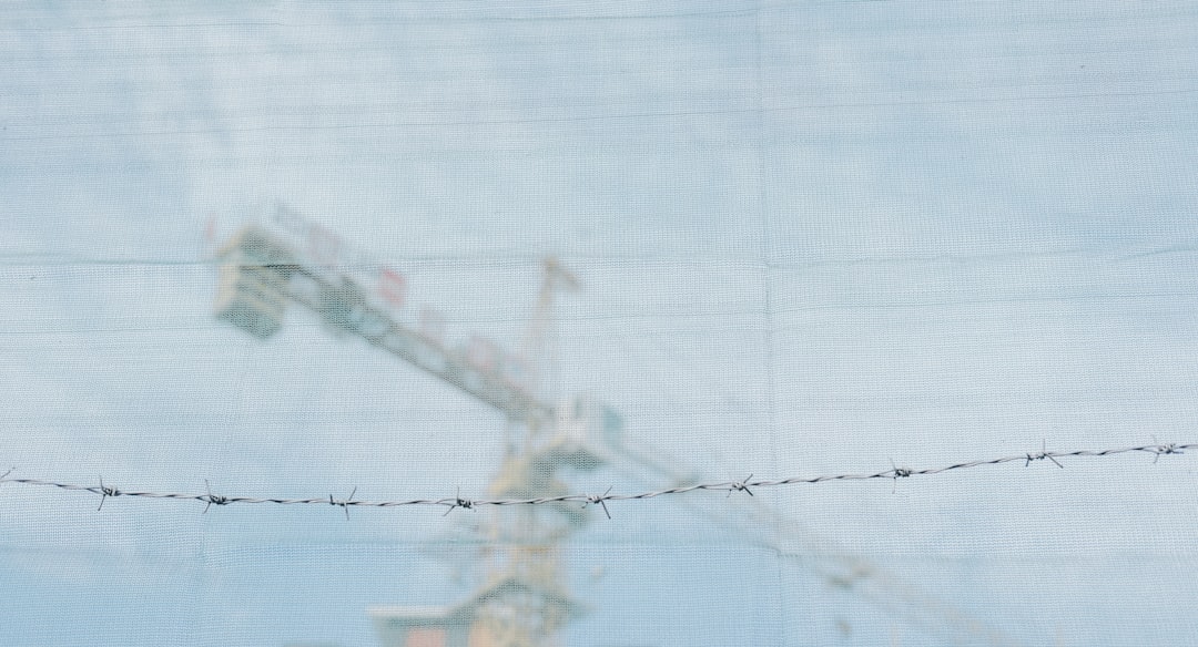A sprawling construction site with multiple cranes working on a massive launch platform, with the ocean in the background.