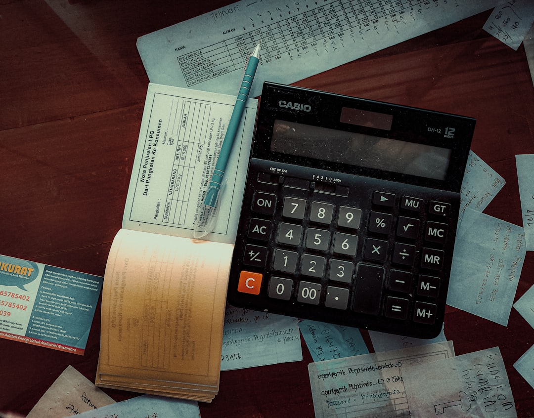 A modern office workspace with financial documents and a calculator on a desk, symbolizing the ongoing corruption investigation.