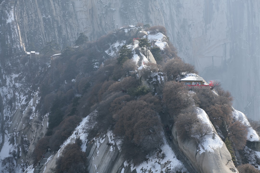 Snow covered car crashed into river near a traditional Chinese house