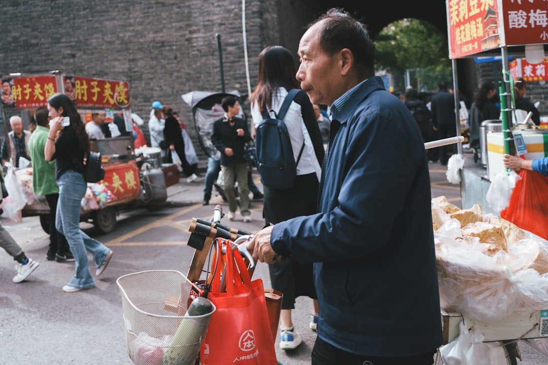 A black and white photo of people lining up outside a grain store in China during the 1970s, with ration cards in hand.